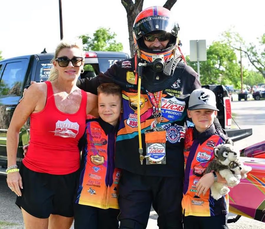 The Logan family in Lucas Oil racing gear beside their dragster
